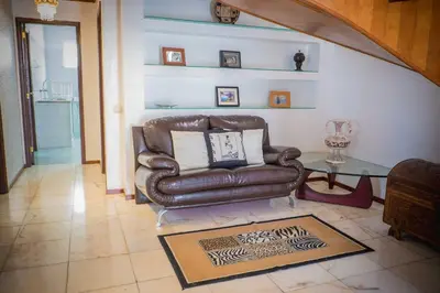 a living room with a leather couch and a table at Gem of a House by Homie in Funchal