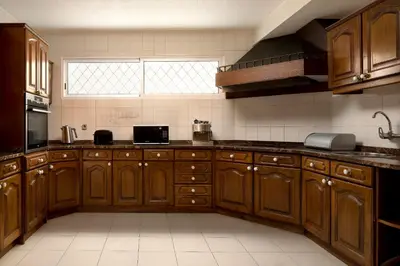 a large kitchen with wooden cabinets and a window at Gem of a House by Homie in Funchal