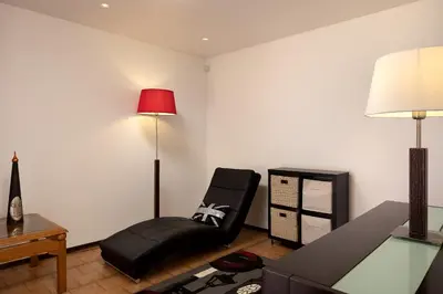 a living room with a black chair and a lamp at Gem of a House by Homie in Funchal