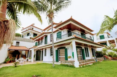a house with palm trees in front of it at Gem of a House by Homie in Funchal