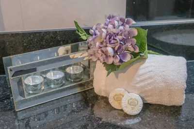 a bouquet of purple flowers in a towel next to candles at Gem of a House by Homie in Funchal