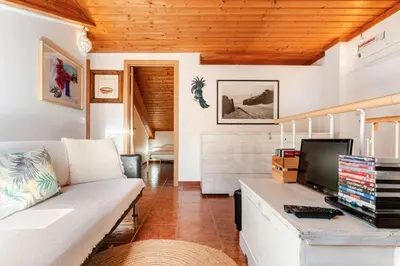 a living room with a couch and a tv at Apartment Praia Arrifana with BALCONY and SEA VIEW in Aljezur