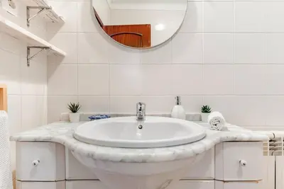 a white bathroom with a sink and a mirror at Apartment Praia Arrifana with BALCONY and SEA VIEW in Aljezur