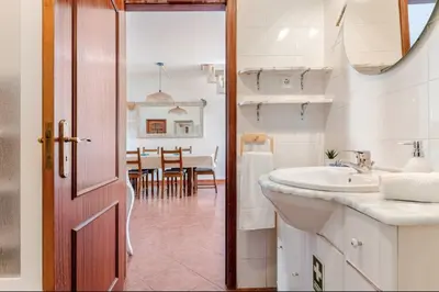 a bathroom with a sink and a mirror and a table at Apartment Praia Arrifana with BALCONY and SEA VIEW in Aljezur