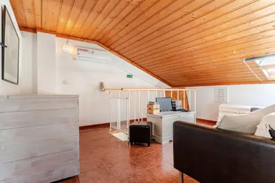 a living room with a couch and a wooden ceiling at Apartment Praia Arrifana with BALCONY and SEA VIEW in Aljezur