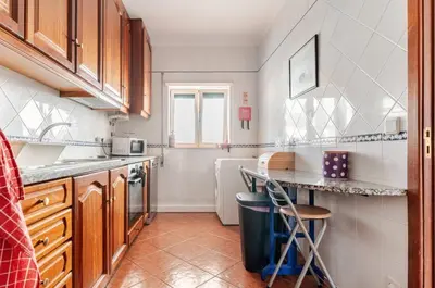 a kitchen with wooden cabinets and a counter top at Apartment Praia Arrifana with BALCONY and SEA VIEW in Aljezur