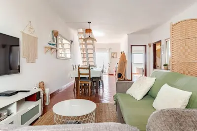 a living room with a green couch and a table at Apartment Praia Arrifana with BALCONY and SEA VIEW in Aljezur