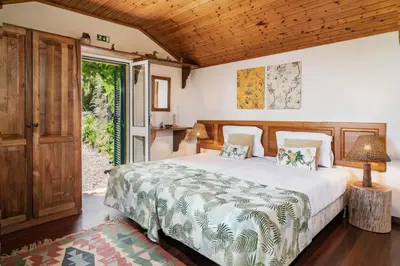 a bedroom with a bed and a door to a yard at Quinta Devónia by An Island Apart in Funchal