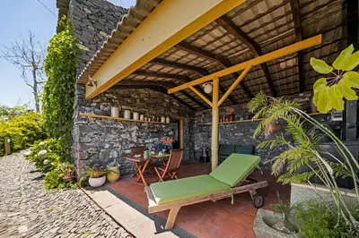 a patio with a green chair and a table at Quinta Devónia by An Island Apart in Funchal