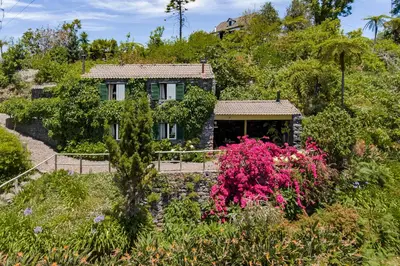 a house on a hill with flowers at Quinta Devónia by An Island Apart in Funchal