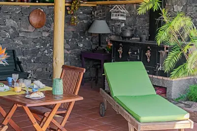 a table and a bench on a patio with a fireplace at Quinta Devónia by An Island Apart in Funchal