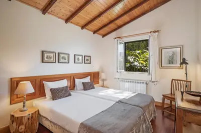 a bedroom with a large bed and a window at Quinta Devónia by An Island Apart in Funchal