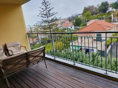 a balcony with a bench and a view of a building at Madeira Luxury Villas Living Funchal in Funchal