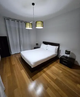 a bedroom with a white bed and wooden floors at Madeira Luxury Villas Living Funchal in Funchal