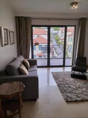 a living room with a couch and a large window at Madeira Luxury Villas Living Funchal in Funchal