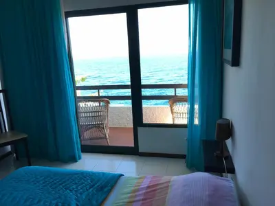a bedroom with a bed and a view of the ocean at Chuva De Prata in Caniço