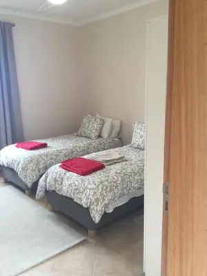 two beds in a room with red towels on them at Banda Do Sol Self Catering Cottages in Estreito da Calheta