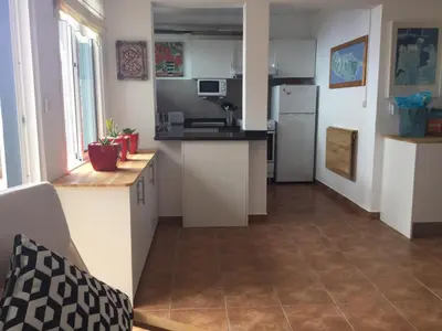 a kitchen with white cabinets and a white refrigerator at Banda Do Sol Self Catering Cottages in Estreito da Calheta