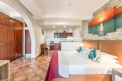 a bedroom with a large bed and a kitchen at Apartments Vista Oceano in Funchal