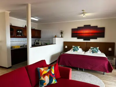 a living room with a bed and a red couch at Apartments Vista Oceano in Funchal