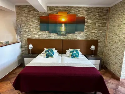a bedroom with a bed with a painting on the wall at Apartments Vista Oceano in Funchal