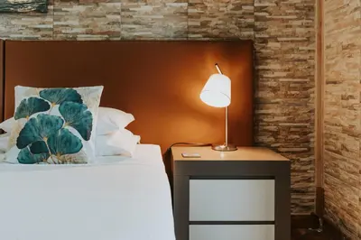 a bedroom with a bed with a lamp on a table at Apartments Vista Oceano in Funchal