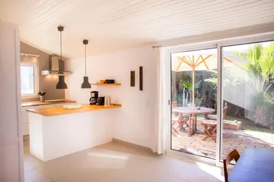 a kitchen with a counter and a table and a patio at Casa da Montanha in Luz