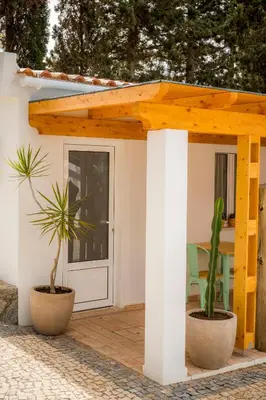 a house with a wooden pergola and two plants at Casa da Montanha in Luz