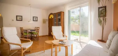 a living room with white chairs and a table at Casa da Montanha in Luz