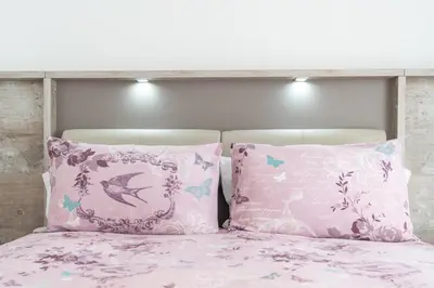 a pink bed with two pillows on it at Casa Leonardo in Arco da Calheta