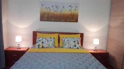 a bedroom with a bed with two lamps on both sides at Lindo Apartamento Villa in Ponta do Sol