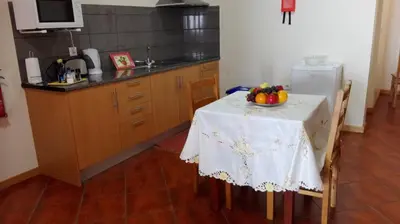 a kitchen with a table with a bowl of fruit on it at Lindo Apartamento Villa in Ponta do Sol