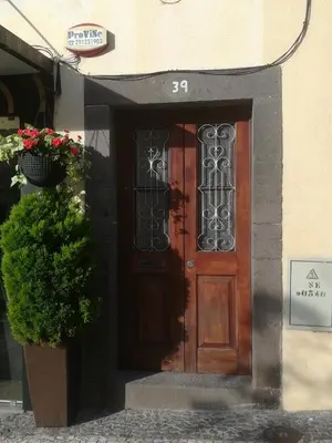 a wooden door on a building with a potted plant at Cc39- Q5 in Funchal