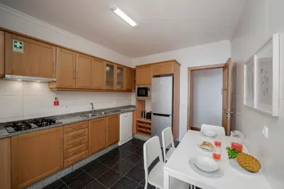 a kitchen with a white table with chairs and a white counter top at Reis Magos III by An Island Apart in Caniço