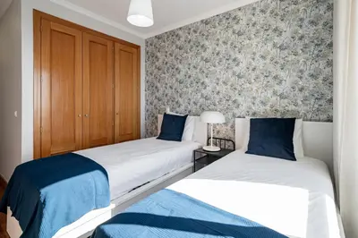 two beds in a room with a wall mural at Reis Magos III by An Island Apart in Caniço