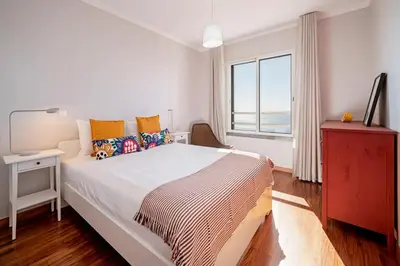 a white bedroom with a large bed and a window at Reis Magos III by An Island Apart in Caniço