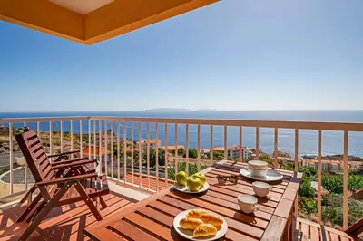 a balcony with a table and a view of the ocean at Reis Magos III by An Island Apart in Caniço
