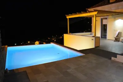 a swimming pool on the roof of a house at night at Villa Escola da Bica in Arco da Calheta