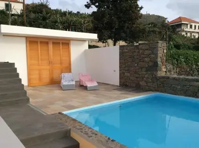 a sunset over the ocean from a swimming pool at Villa Escola da Bica in Arco da Calheta