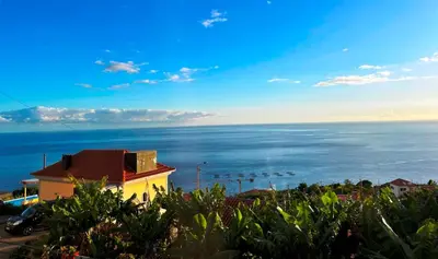 a view of the ocean with the sun in the sky at Villa Escola da Bica in Arco da Calheta