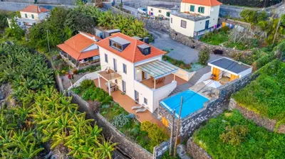 a porch with chairs and a view of the ocean at Villa Escola da Bica in Arco da Calheta