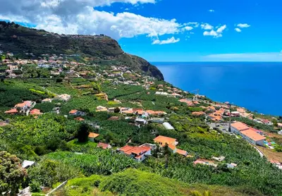 a small village on a hill next to the ocean at Villa Escola da Bica in Arco da Calheta