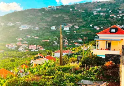 a small town on a hill next to the water at Villa Escola da Bica in Arco da Calheta