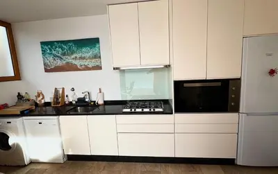 a kitchen with white cabinets and a stove top oven at Villa Escola da Bica in Arco da Calheta