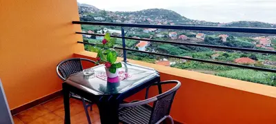 a table and chairs with a view from a balcony at Appartamento Villa in Ponta do Sol