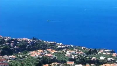 an airplane is flying over a town on a hill at Appartamento Villa in Ponta do Sol