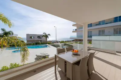 a balcony with a table and chairs and a view of the ocean at Porto de Mós 85 by Destination Algarve in Lagos