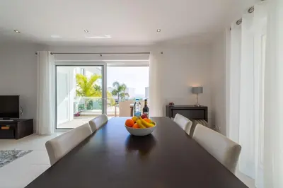 a dining room with a table with a bowl of fruit on it at Porto de Mós 85 by Destination Algarve in Lagos