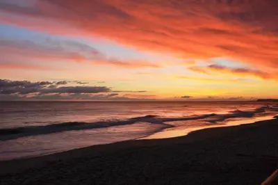 a sunset on a beach with the ocean at Porto de Mós 85 by Destination Algarve in Lagos