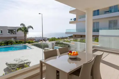 a dining room with a table and chairs and a pool at Porto de Mós 85 by Destination Algarve in Lagos